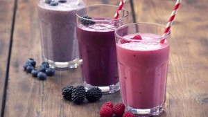 berry smoothies in glasses with straws